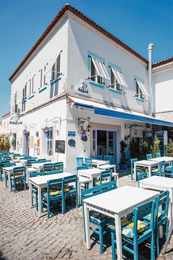 Beyaz ve turkuaz tonlarıyla Alaçatıda restoran görüntüsü