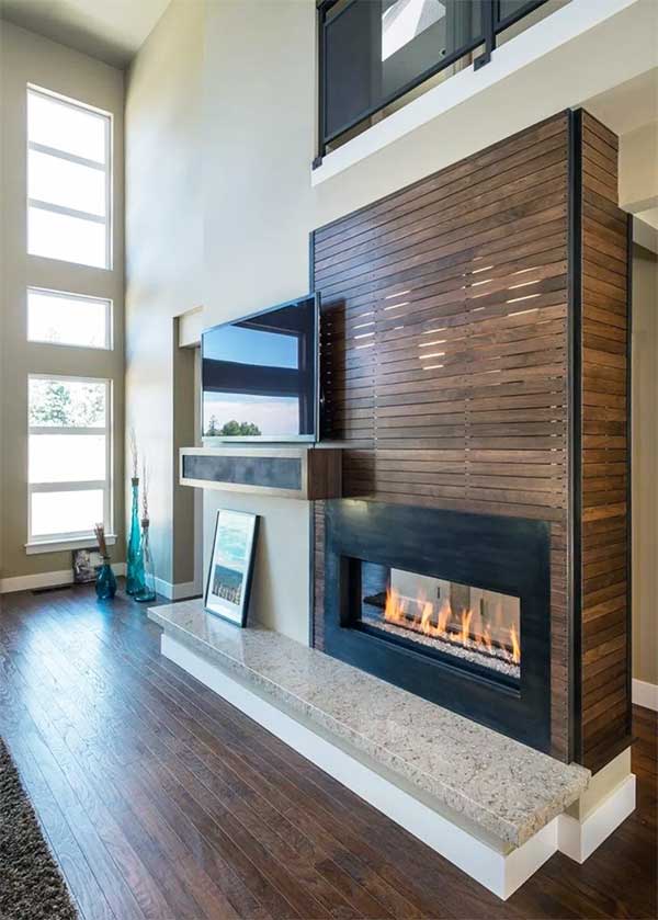 Ahşap ve mermerin bütünleştiği şömineli ve televizyonlu bir duvar