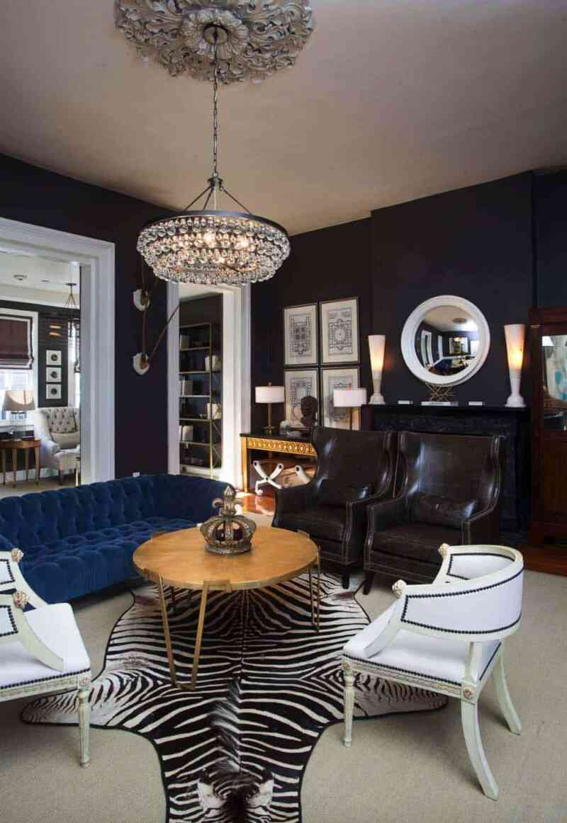 Beyaz sahte zebra derisi halı, gösterişli avize, beyaz çerçeveli geçişlerle sim siyah duvarlı tasarımlara mükemmel bir örnek.