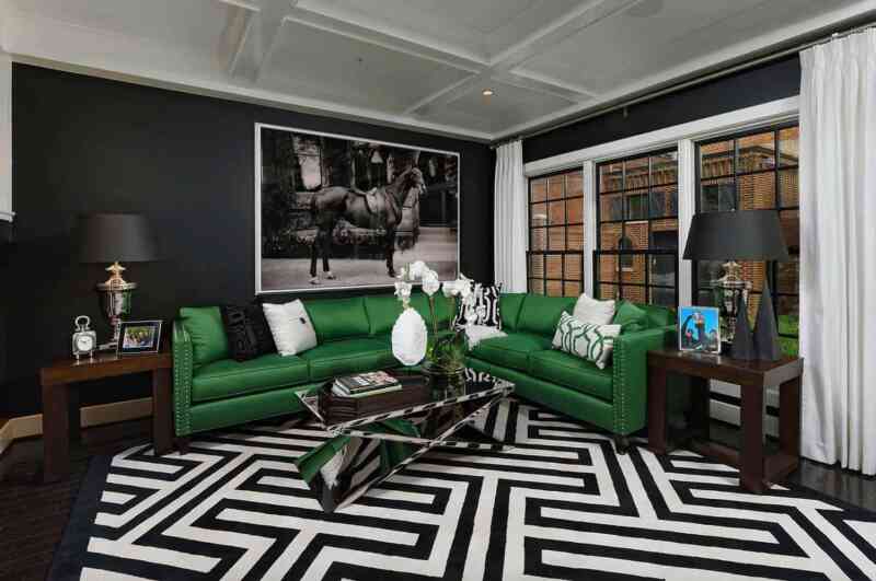 Geometrik desenli siyah beyaz halı, ve canlı yeşil koltukla modern bir tasarım.
