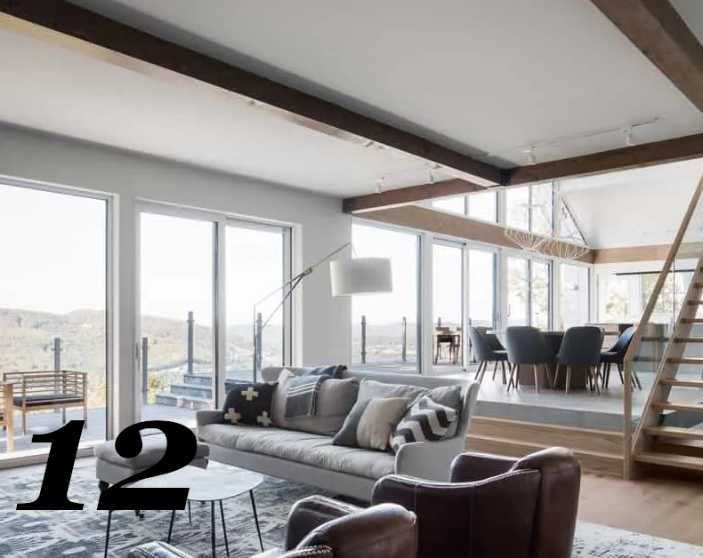 Açık stil büyük odanın parlaklığı, bol miktarda doğal ışık sağlayan cam duvarlardan kaynaklanmaktadır. Beyaz tavanın koyu ahşap kirişleri ile modern tarzda bu oda harika eşleşmiş.